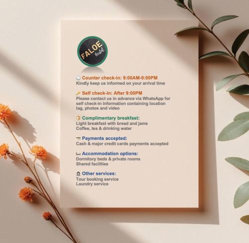 a menu for a restaurant on a white table with flowers at Faloe Hostel in Kota Kinabalu