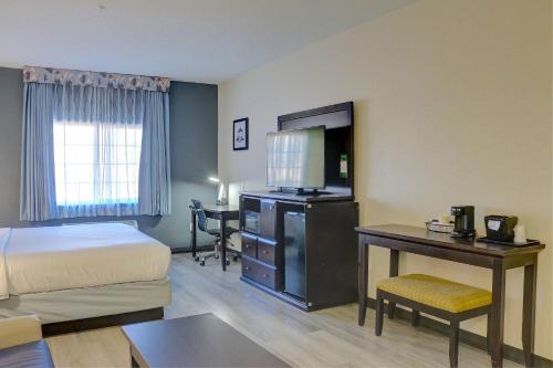 a hotel room with a bedroom with a bed and a desk at Quality Inn & Suites Roswell North in Roswell