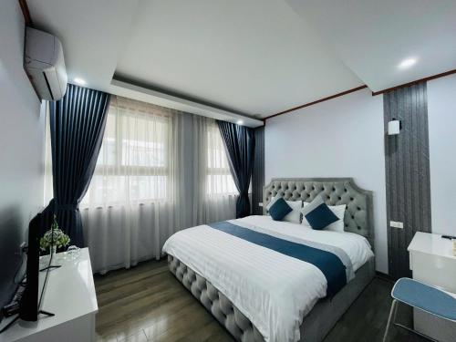 a bedroom with a large bed with blue pillows at Home Villa TP Giao Lưu in Hanoi