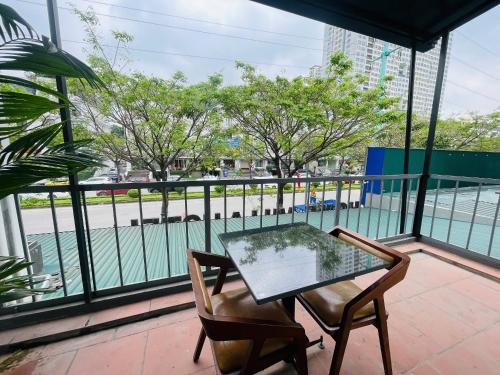 a glass table and chairs on a balcony with a view at Home Villa TP Giao Lưu in Hanoi
