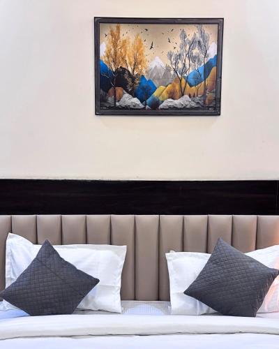 a picture hanging above a bed with pillows at Barsana Suites in Vrindāvan