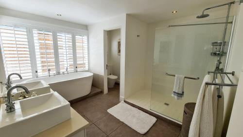 a bathroom with a tub and a sink and a shower at Luxury 3BR Direct Beach Access & Pool in Cap Malheureux