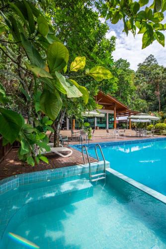 a swimming pool in a resort with trees at Bidaisari Resort in Kampong Sum Sum
