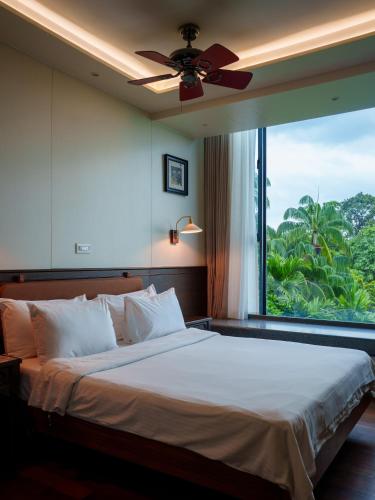 a bedroom with a large bed with a large window at Siloso Beach Resort - Sentosa in Singapore