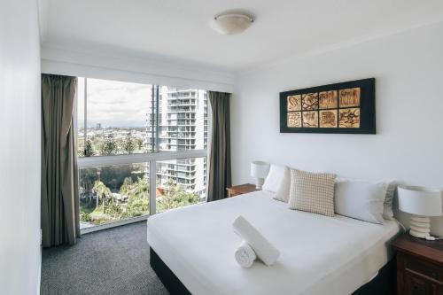 a bedroom with a white bed and a large window at The Crest Apartments - Main Beach in Gold Coast