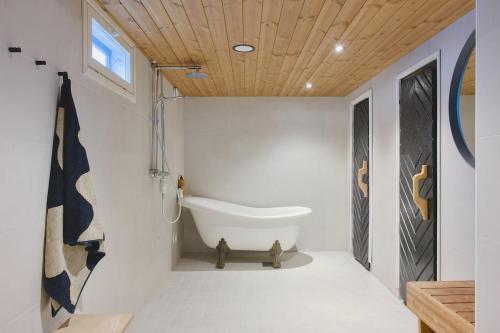 a bathroom with a tub in the corner of the room at Villa Rimppari täydellinen porukalle 9 hlö puusauna nuotiopaikka ja parkki in Oulu