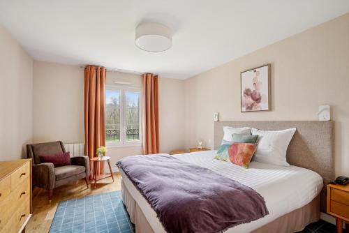 a bedroom with a bed and a chair and a window at MH Hôtel & Spa Arradon - Golfe du Morbihan in Arradon