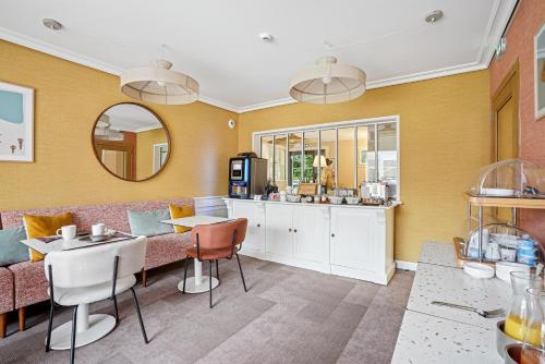 a dining room with a table and a counter at MH Hôtel & Spa Arradon - Golfe du Morbihan in Arradon