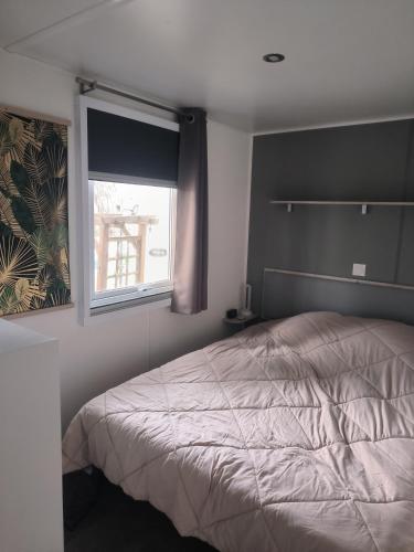 Un dormitorio con una cama y una ventana. en Ohana, en Puget-sur-Argens