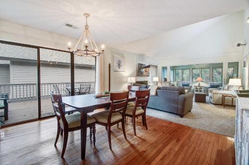 a dining room and living room with a table and chairs at West Beach Oceanwoods Cottage 442 in Kiawah Island