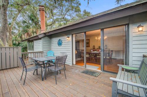 a patio with a table and chairs on a deck at West Beach Oceanwoods Cottage 442 in Kiawah Island