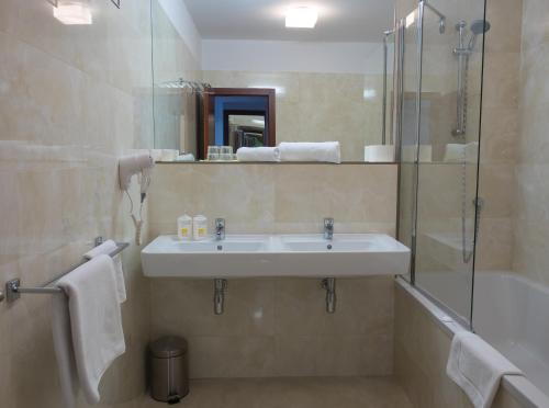 a bathroom with a sink and a shower and a tub at Hotel Cvilín in Krnov