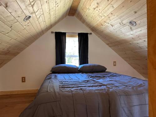 a bed with two pillows on it in a attic at Mountains Edge Bungalow in Sayward