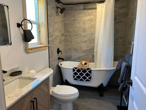 a bathroom with a tub and a toilet and a sink at Mountains Edge Bungalow in Sayward