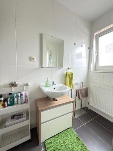 a white bathroom with a sink and a mirror at Bogi's Ferienhaus - Pension in Laakirchen