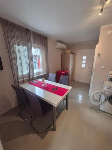 a dining room table with chairs and a red table cloth at Apartmani Mia in Karlobag