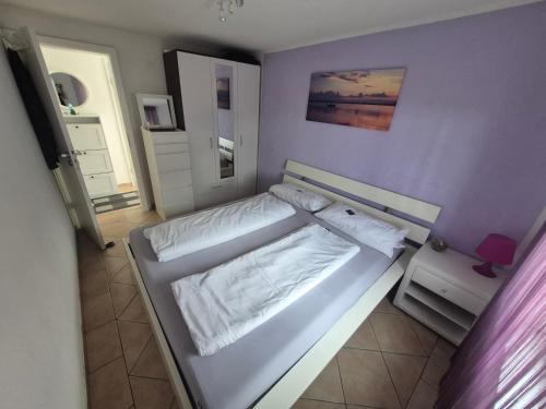 a large white bed in a purple bedroom at Apartmani Mia in Karlobag