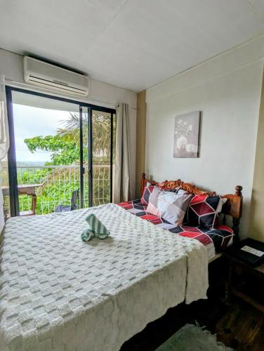 a bedroom with a bed and a large window at Tagaytay Resthouse 3 big rooms in Ulot