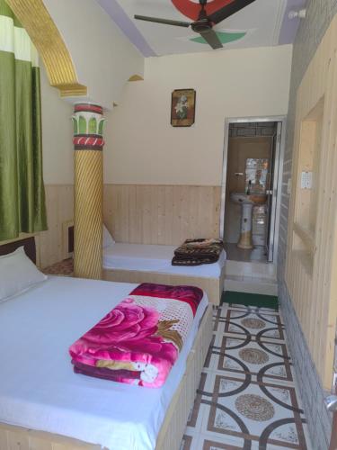 a bedroom with two beds and a ceiling fan at Dev Niwas in Nākuri