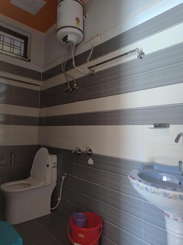 a bathroom with a toilet and a sink at Dev Niwas in Nākuri