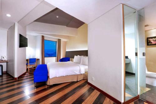 a hotel room with a bed and a glass wall at Aston Palembang Hotel & Conference Centre in Palembang