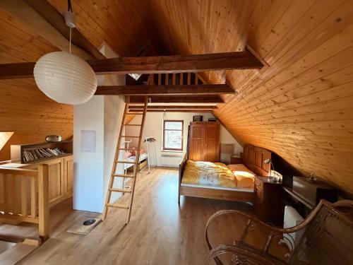 a attic room with a bed and a ladder at Chata Anežka in Stará Ves
