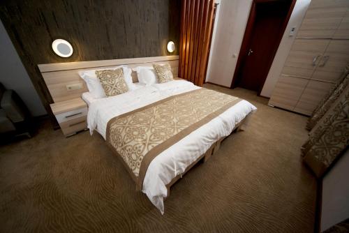 una habitación de hotel con una cama grande en una habitación en Iberia Didube en Tiflis