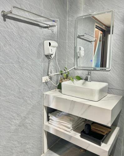 a bathroom with a sink and a mirror at LePont Cat Ba Bungalow in Cat Ba