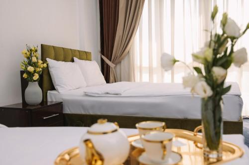 a bedroom with a bed and a table with a vase of flowers at Чынар Отель in Änew