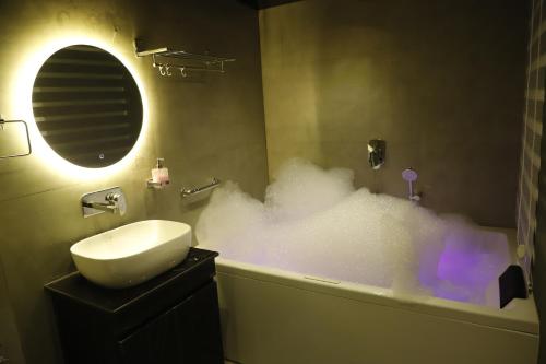 a bathroom with a bath tub covered in foam at Grenelle-Indirapuram in Ghaziabad