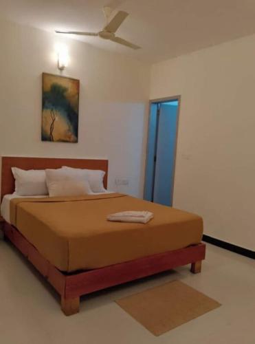 a bedroom with a bed with a ceiling fan at Hangout at Nandi Hills in Nandigunda