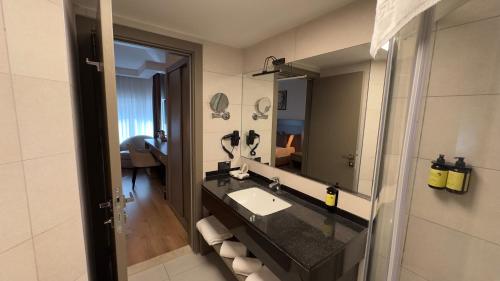 a bathroom with a sink and a mirror at Adana Time Business Hotel in Adana