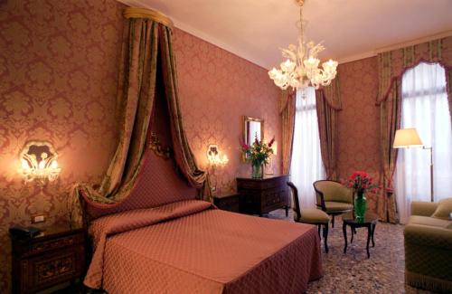 a bedroom with a bed and a chandelier at Casa Pisani Canal in Venice