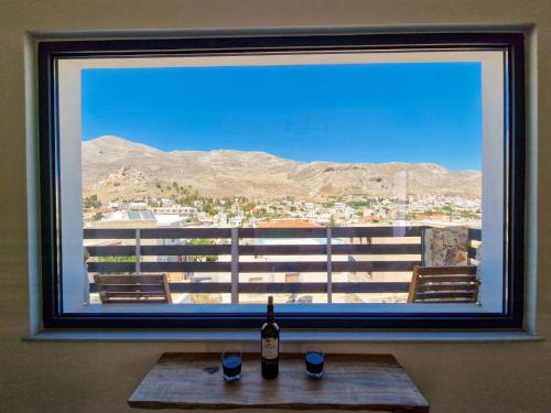 a bottle of wine sitting on a table in front of a window at family MARIA in Kalymnos
