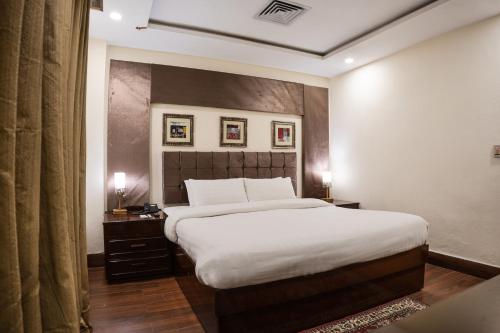 a bedroom with a large bed in a room at Hotel One Faisalabad in Faisalabad