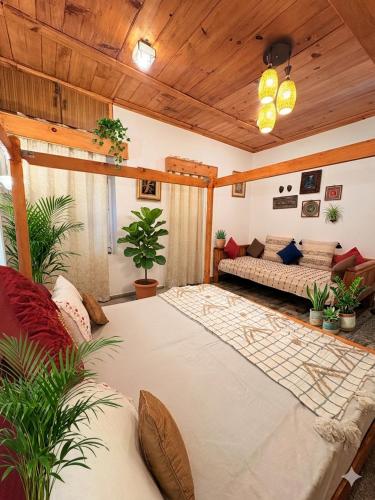a living room with a large bed and a couch at The Shivdhaar Estate kud'Patnitop in Kūd