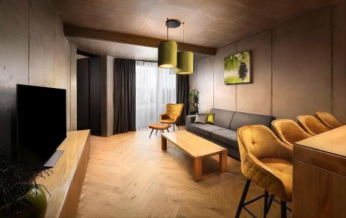 a living room with a couch and a tv at Tatry Premium Apartment - PRIVATE Parking in Kežmarok