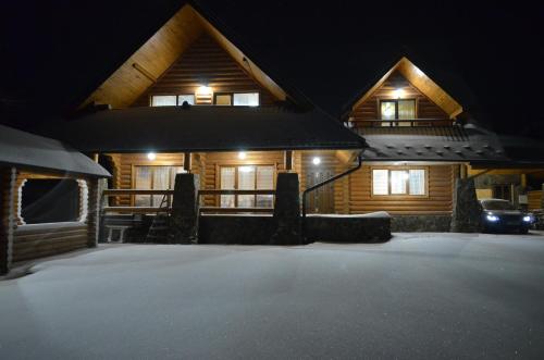 a cabin at night with snow in front of it at Sadyba Pikuy in Bilasovytsya