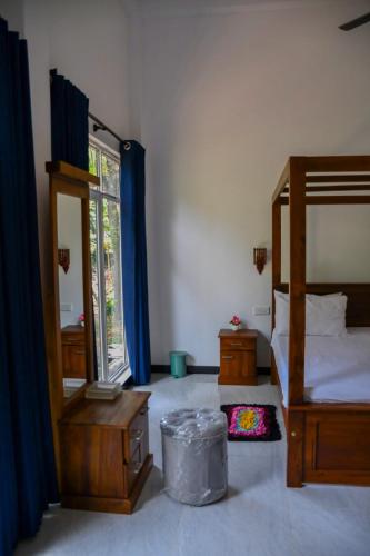 a bedroom with a bed and a mirror and a window at Vishu villa in Galle