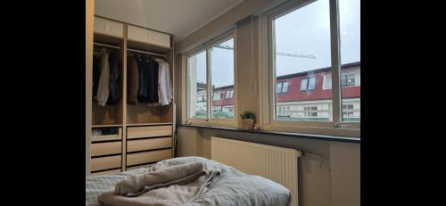 a bedroom with windows and a bed in a room at Apartment Bergen Central - private balcony in Bergen
