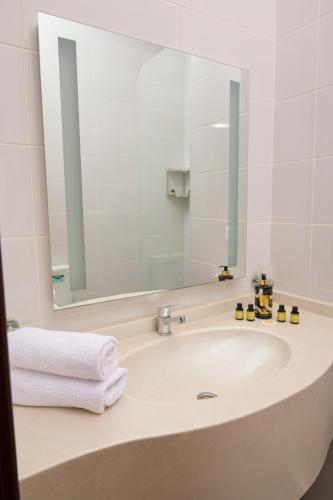 a bathroom with a sink with a mirror and towels at Чынар Отель in Änew