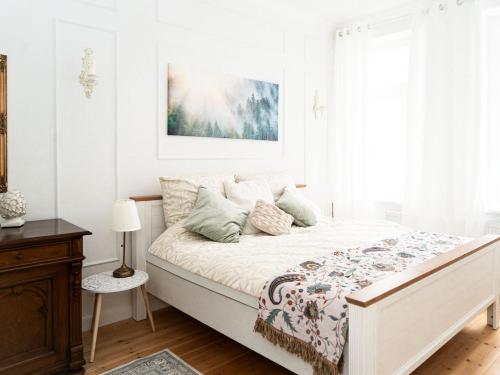 a white bedroom with a large bed with a bedspread at Altstadt Geverdes 2 in Lübeck
