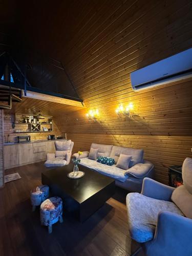 a living room with a couch and a table at SilenT Hill Cottage in Gant'iadi