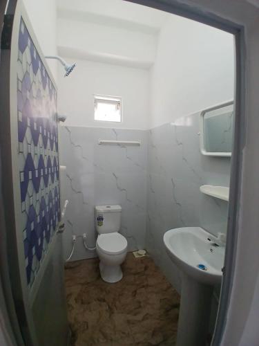 a bathroom with a toilet and a sink at AMM Rooms in Nikawatawana