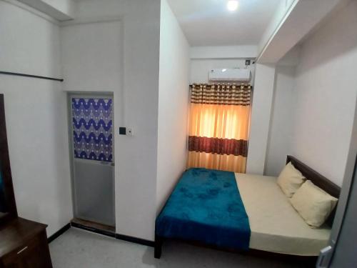 a small bedroom with a bed and a window at AMM Rooms in Nikawatawana