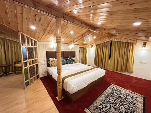 a bedroom with a bed in a room with wooden ceilings at The Riviera Hotel Pahalgam in Pahalgām