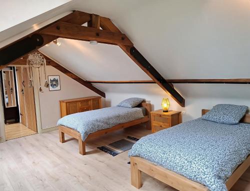 two beds in a room with a attic at Cottage Les Séquoias de l'Oust Clim mobile in Malestroit