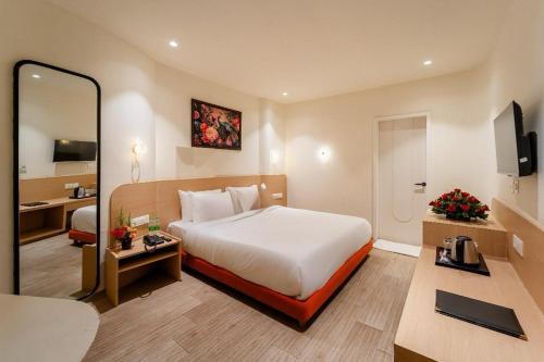 a hotel room with a bed and a mirror at Hotel Benchmark Premier in Indore
