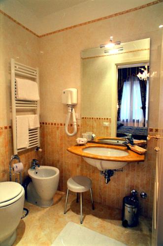a bathroom with a sink and a toilet and a mirror at Casa Pisani Canal in Venice