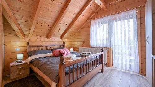 a bedroom with a bed in a log cabin at Villa Nina by Villas Guide in Ludbreg